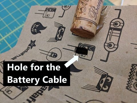 Hole cut for the battery cable below the cork