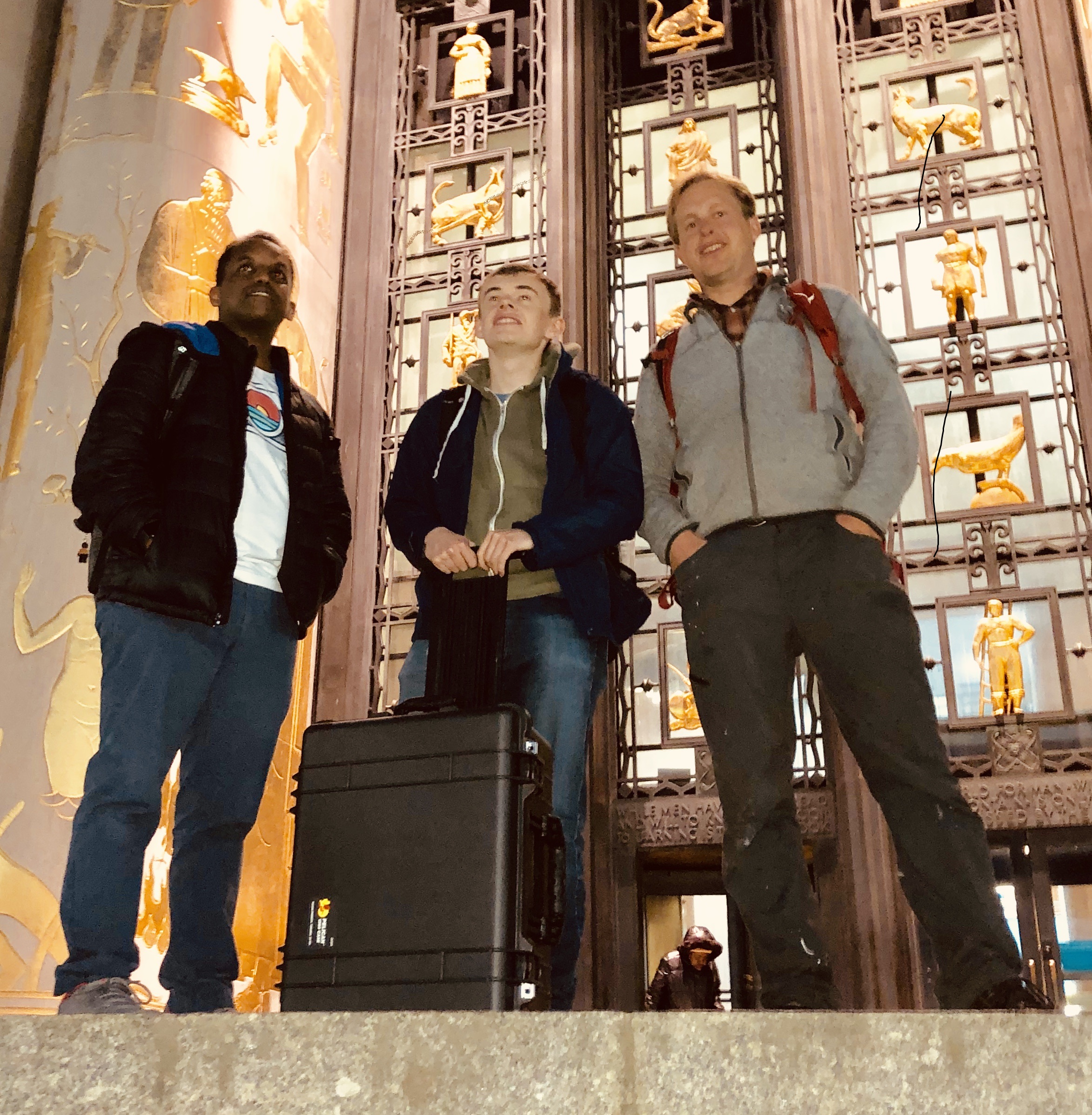 Teddy Seyed, James Devine and Peli de Halleux standing in front of the Brooklyn Public Library