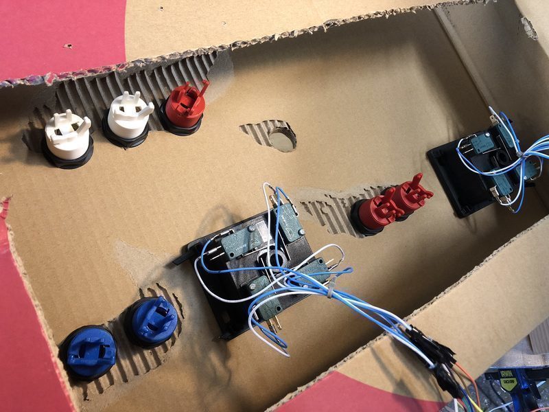 Buttons and joysticks inserted into the cardboard box